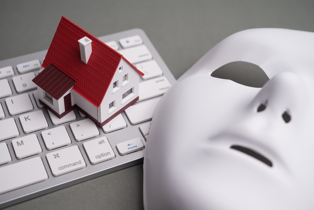 Teclado de ordenador, casa y máscara de estafador